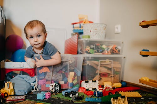 Free A Boy Sitting Inside a Plastic Toy Box Stock Photo