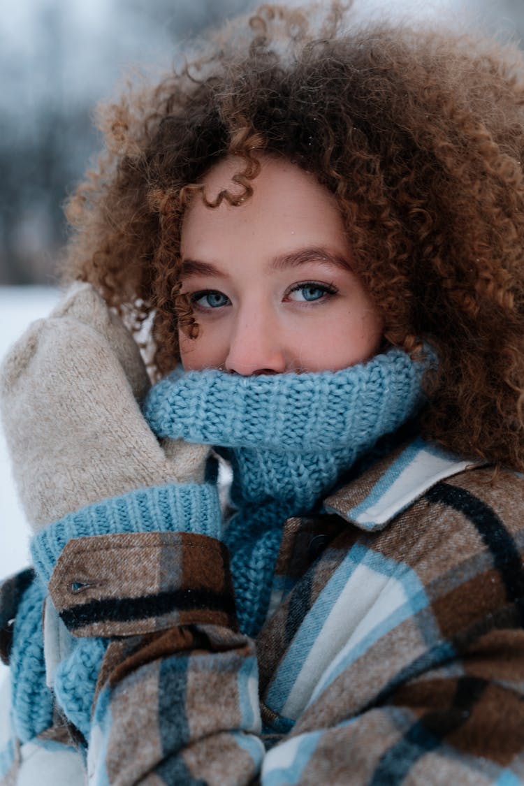 Portrait Of Woman Covering Face With Blue Sweater