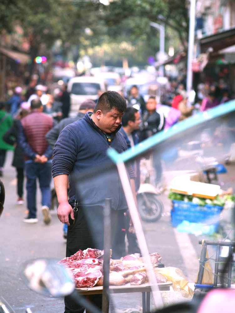 Man Looking At Meat On The Market Stall