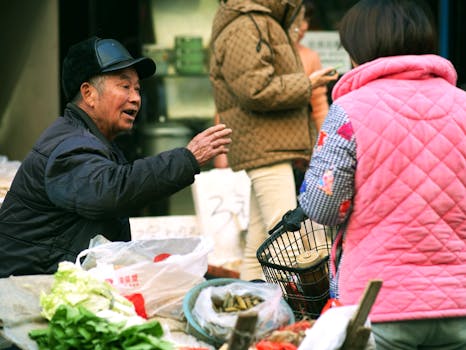 A vibrant street market scene showcasing a vendor in conversation with a customer, surrounded by fresh produce.