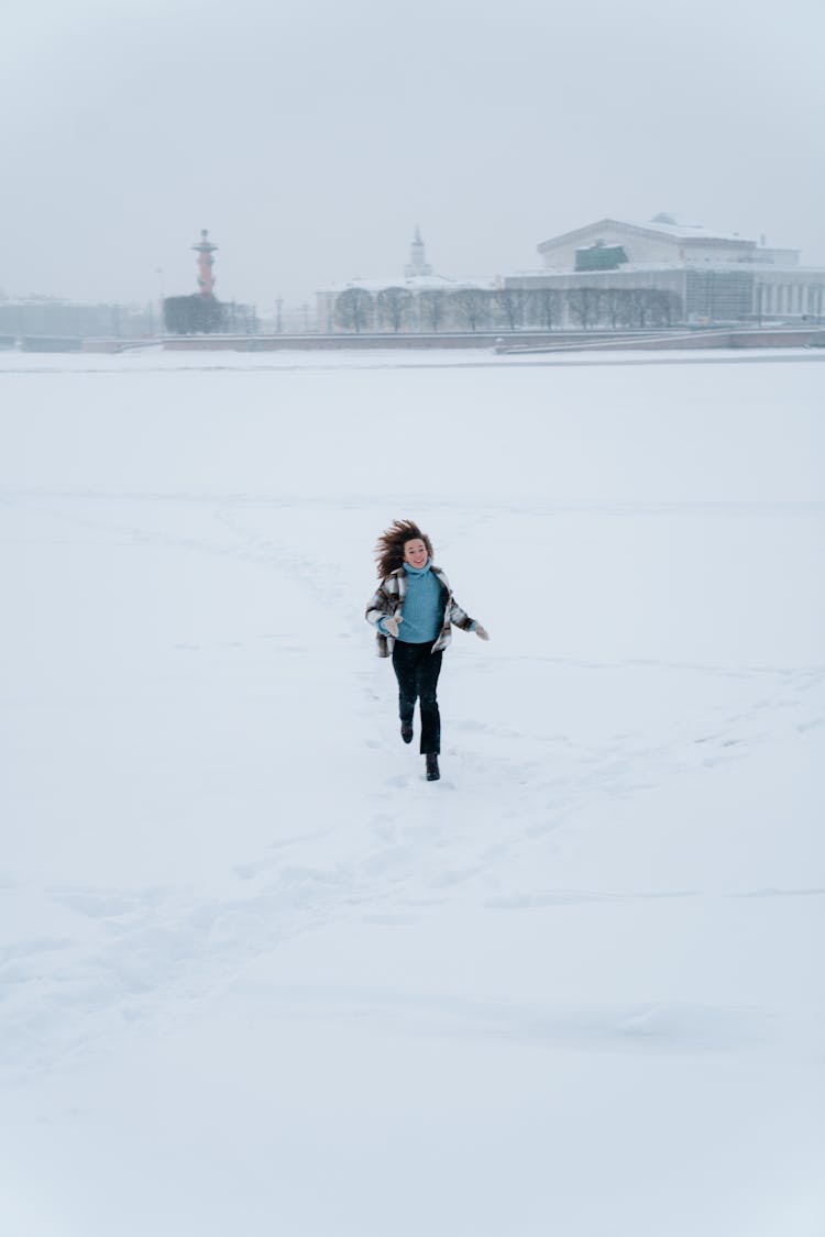 Curly Haired Woman Running In Snow