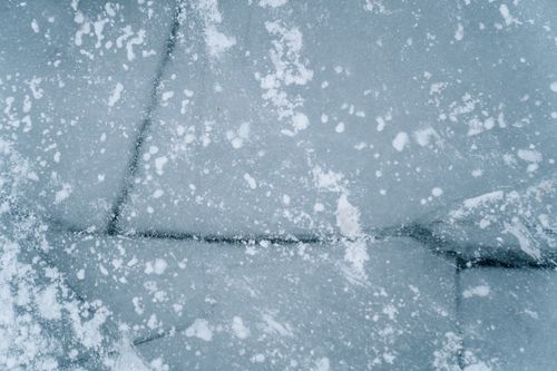 Free Detailed view of snowflakes on frozen ice, capturing winter's chill Stock Photo