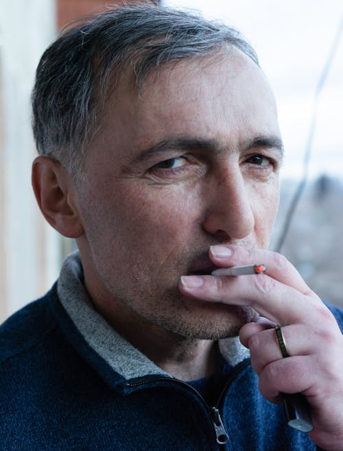 Close Up Photo of a Man Smoking Cigarette