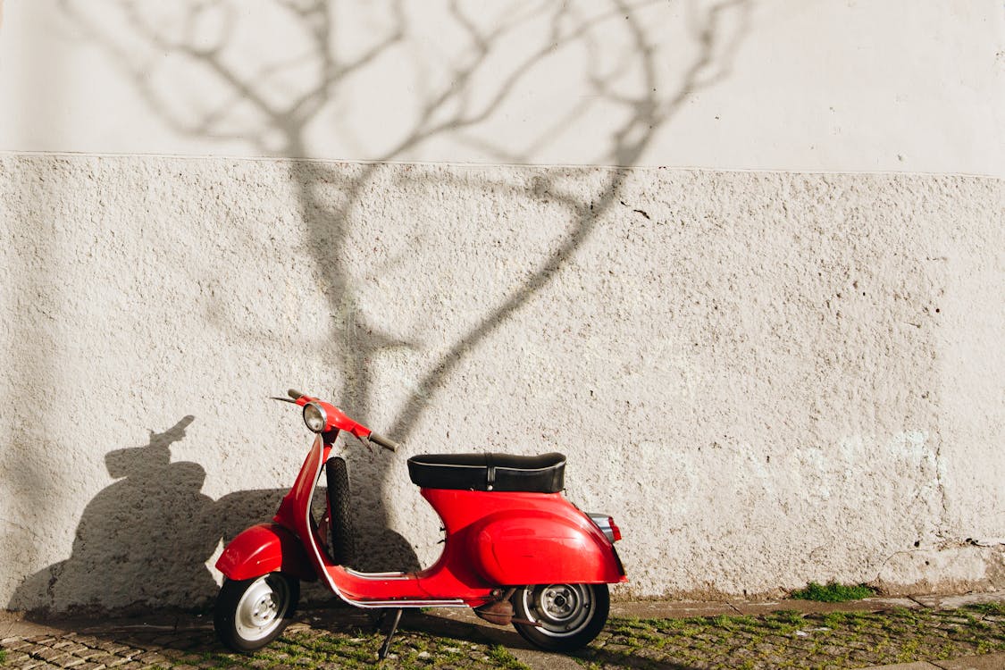 Roter Motorroller In Der Nähe Der Wand