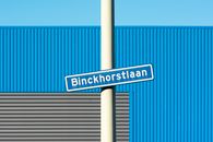 A White and Blue Sign Posted on a White Pole