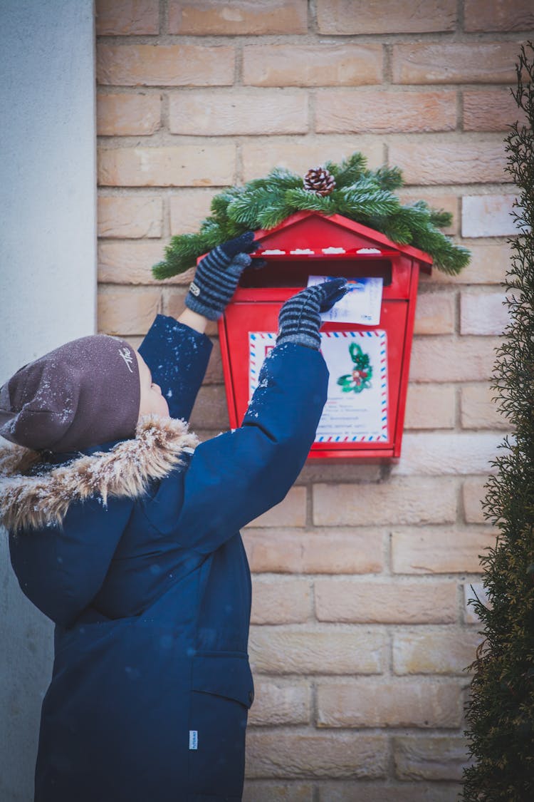 Child Dropping Letter Into Decorated Mailbox