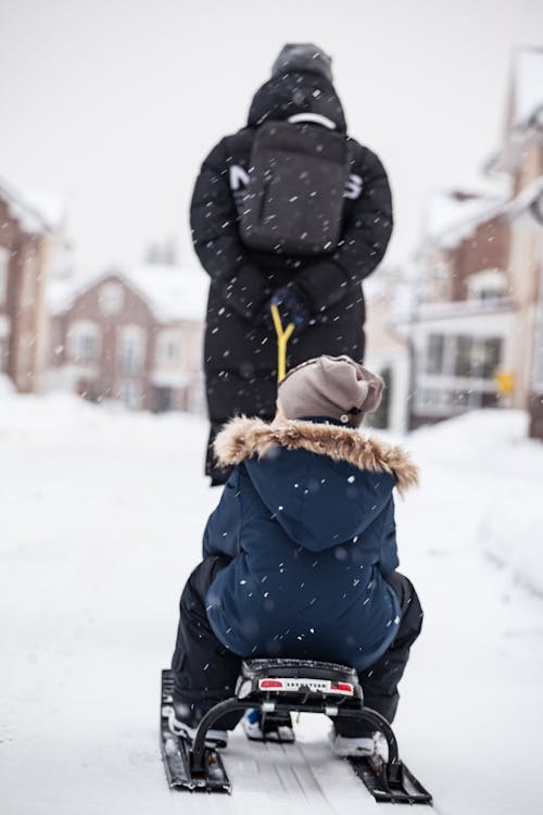 Person Pulling Child on Sled