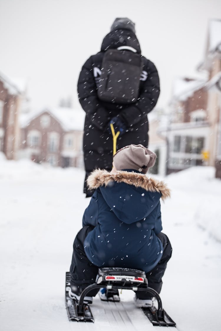 Person Pulling Child On Sled