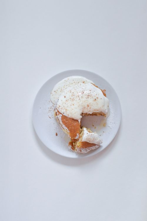 Free A mouthwatering pastry topped with white cream on a ceramic plate, perfect for dessert lovers. Stock Photo
