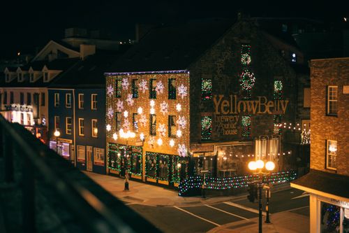 Free Charming urban scene with Christmas lights adorning buildings on a festive night. Stock Photo