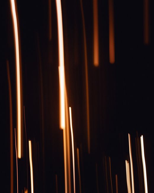 Abstract image featuring long exposure light streaks on a dark background with a neon glow.