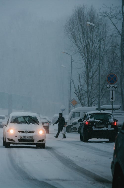 Free A Person Crossing the Busy Road on a Snowy Day Stock Photo