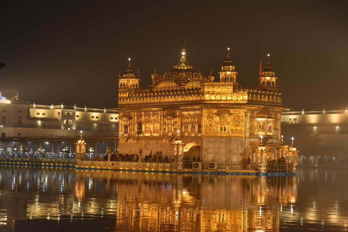 The Golden Temple in Amritsar illuminated at night, reflected in the sarovar