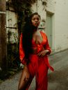 Attractive Woman in Long Red Dress Standing in Provocative Pose in Suburb Street