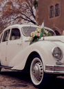 White Volkswagen Beetle Parked Beside Brown Concrete Building