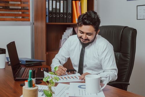 Free Young businessman working at desk in a professional office setting in Dubai. Stock Photo
