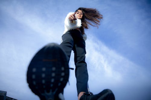 A Low Angle Shot of a Woman in White Fur Coat