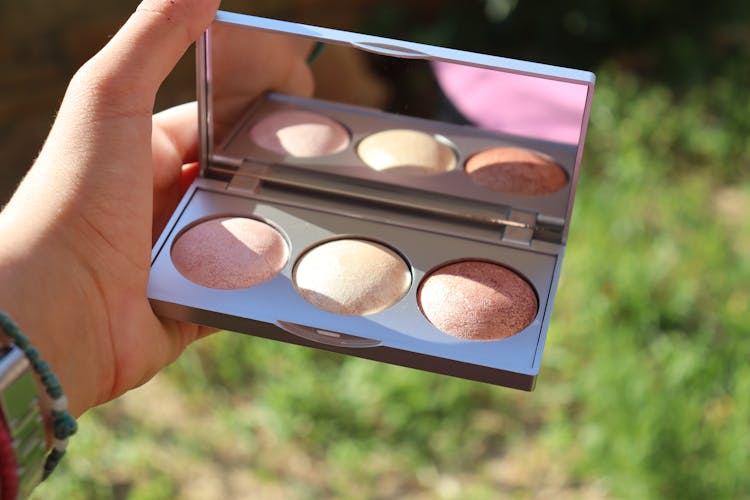 A Person Holding A Blush Palette With Mirror