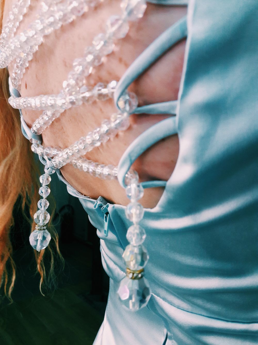 Decorative beading across the back of a blue dress