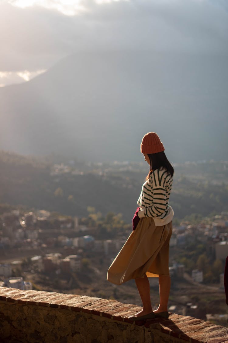 A Woman Standing On The Edge Of A Cliff 