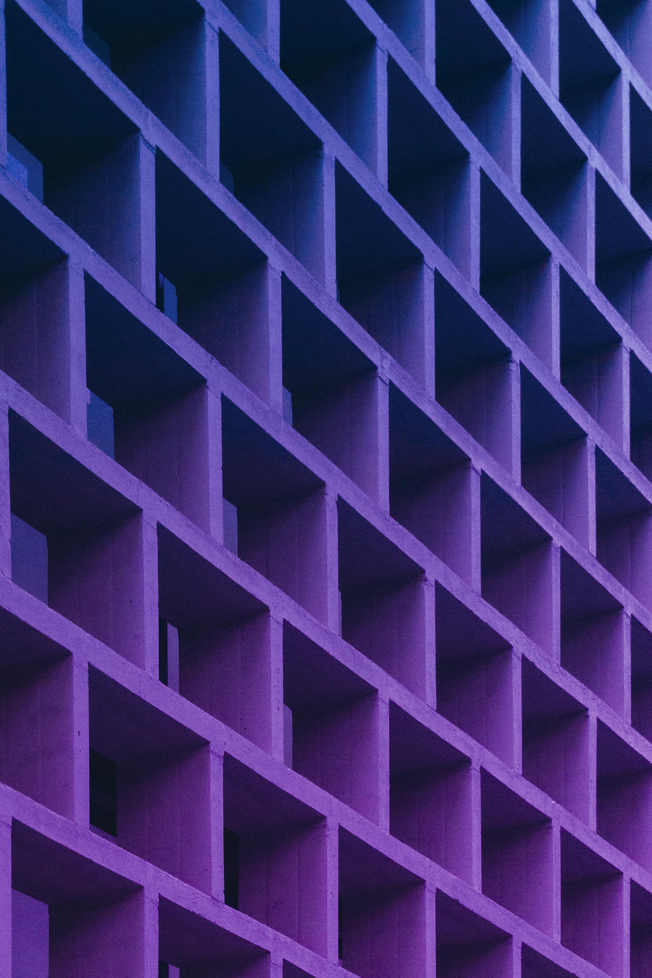 Dynamic modern facade in Valencia with a striking purple tone showing urban architectural style.