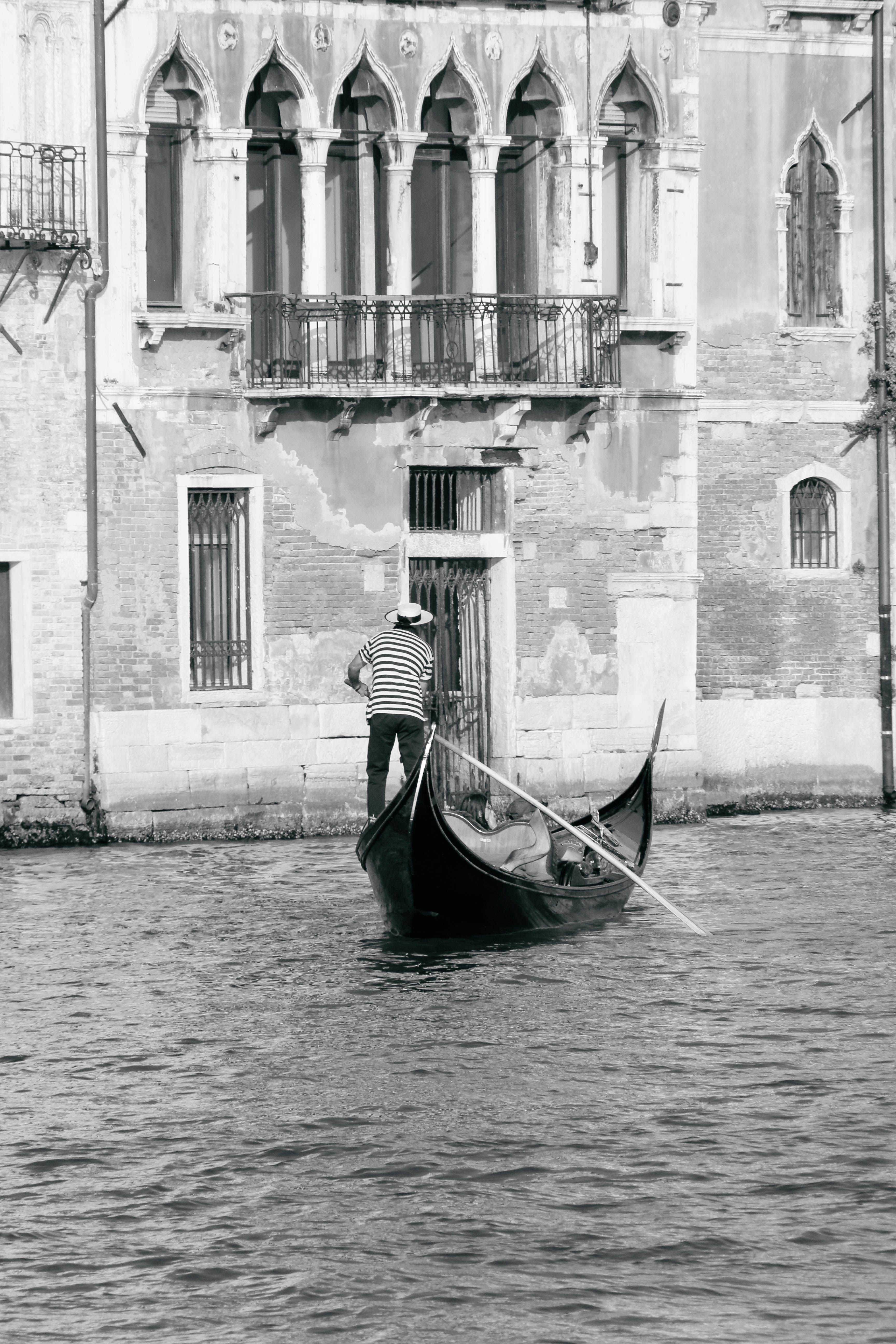 A gondolier sails a traditional gondola along the historic canals of Venice, Italy.