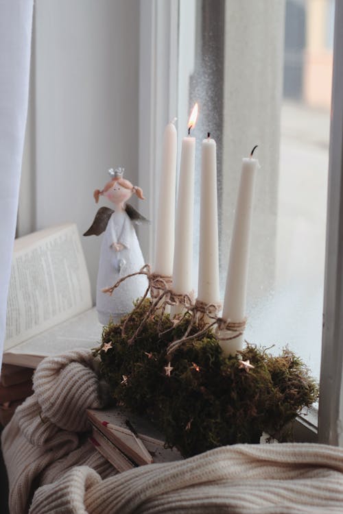 Wax Candles and Toy Angel on Window