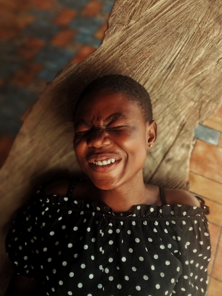 Woman In Polka Dot Shirt Laughing With Eyes Closed