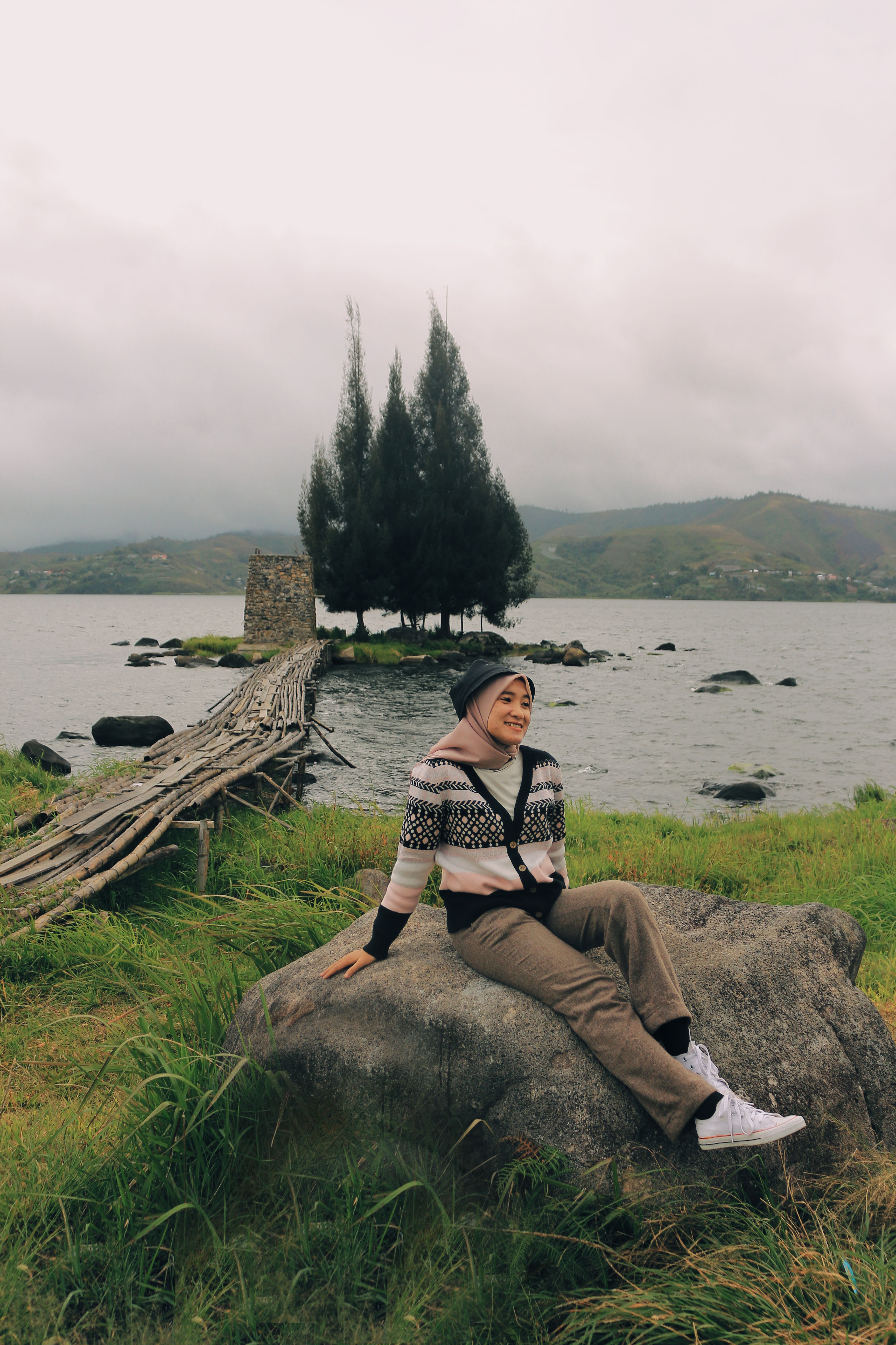 Woman Sitting on a Rock Near Body of Water · Free Stock Photo