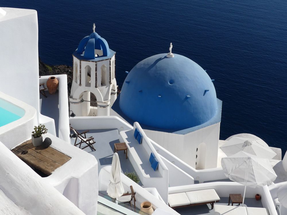 Blue-domed church and whitewashed terraces above the deep blue caldera