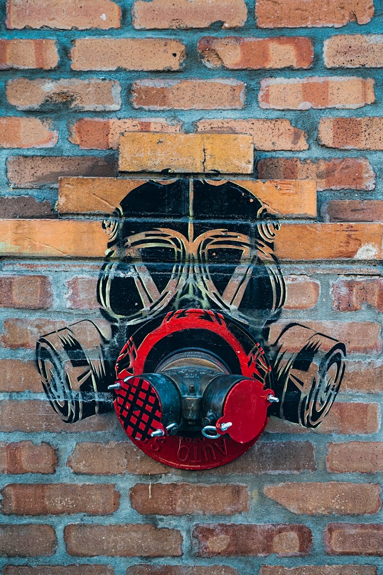 Black Gas Mask Stencil Picture On Brick Wall With Fire Hydrant