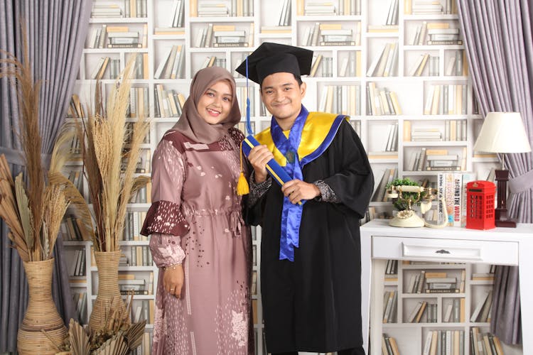 Woman And Man In Graduation Gown And Dress