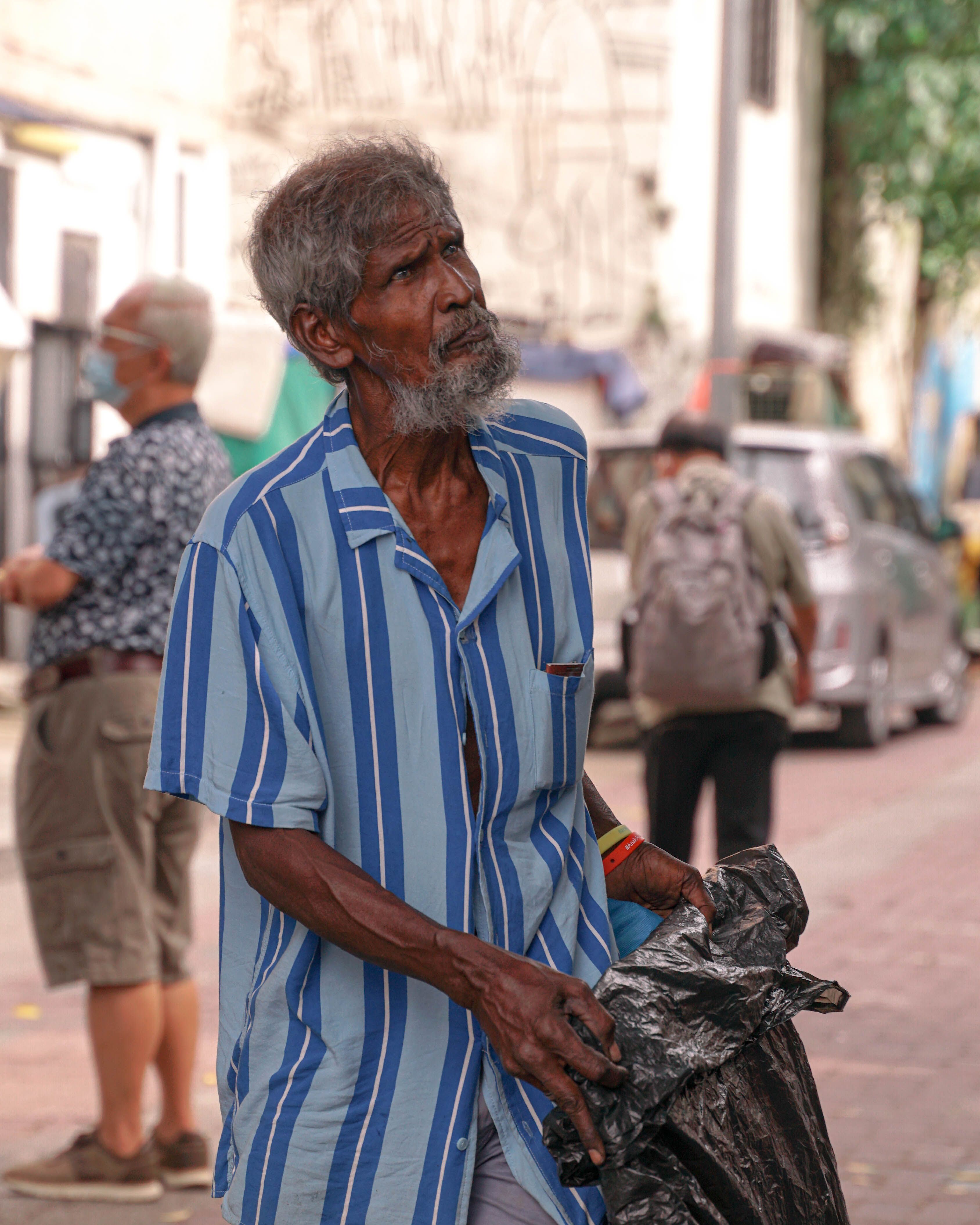 elderly man holding a plastic bag