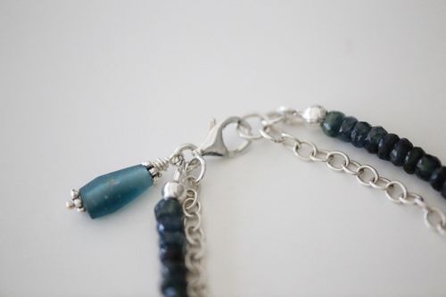 Free Detailed view of a silver necklace clasp and beaded chain with blue accents. Stock Photo