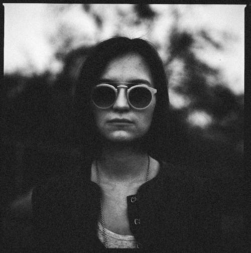 Grayscale Photo of a Woman Wearing Her Sunglasses