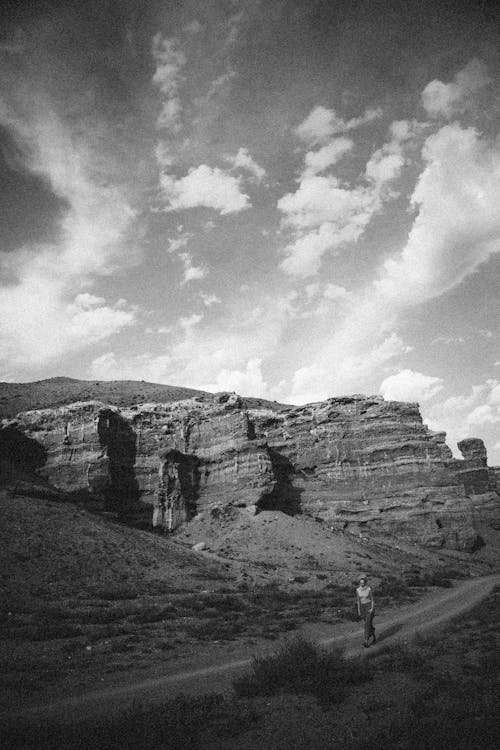 Dirt Road along Rock Formation in Black and White