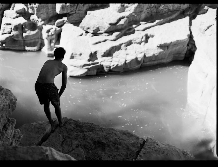 Back View Of A Man Standing On A Cliff 