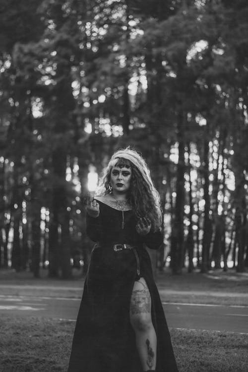 Grayscale Photo of Woman in Black Coat Standing on Road