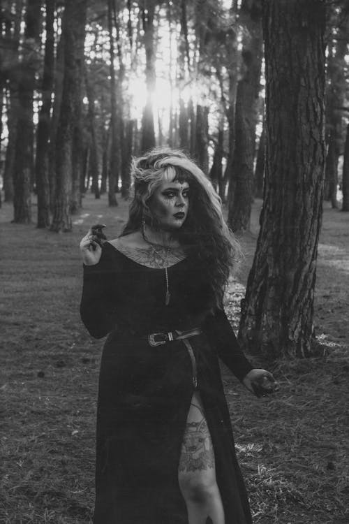 Woman in Black Long Sleeve Dress Standing in the Forest