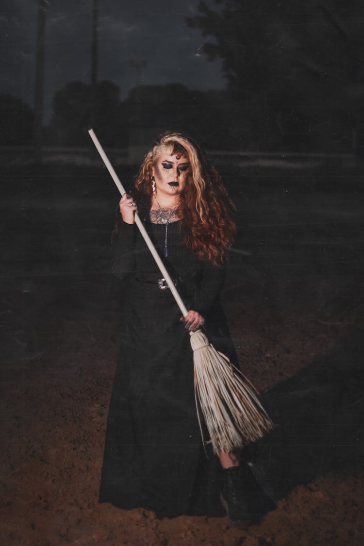 Portrait Of Woman In Witch Costume Holding Broom