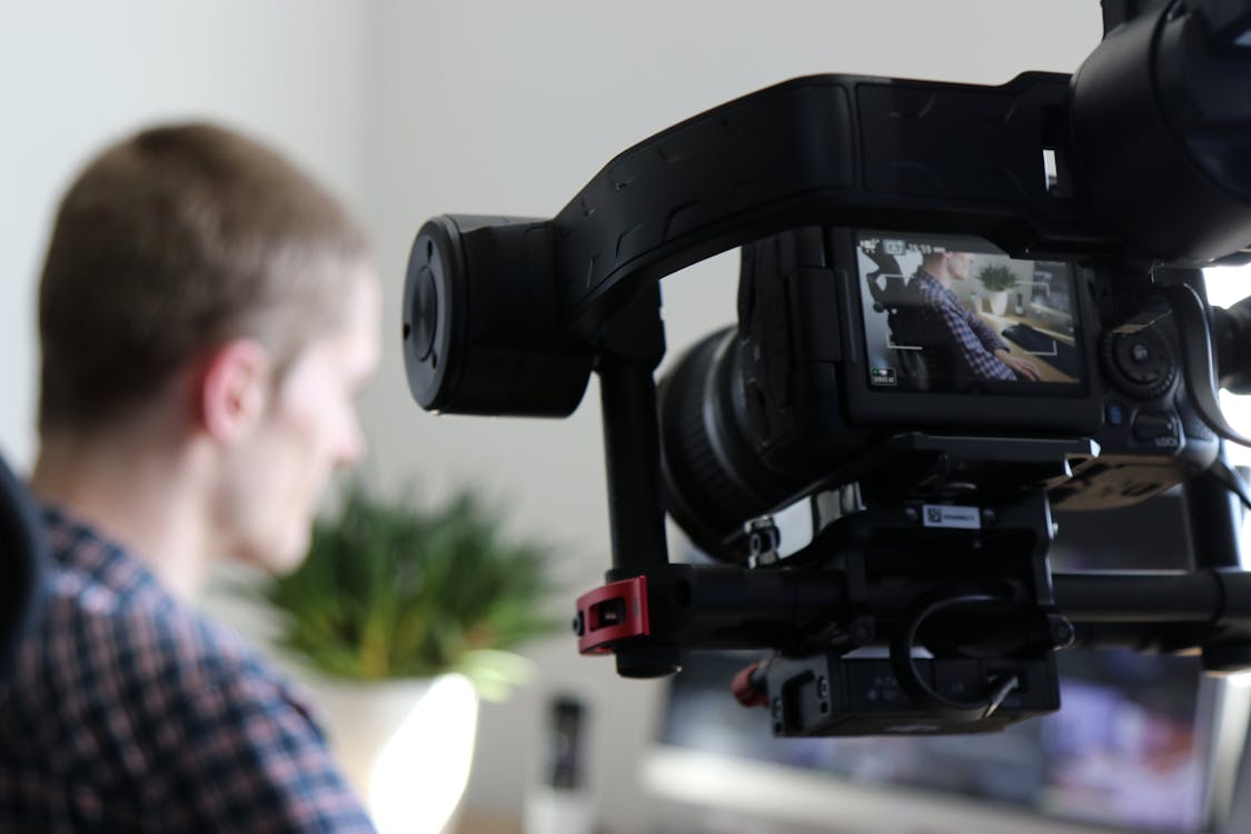 Free Black Video Camera Turn on Next to Man Wears Black and Gray Shirt Stock Photo