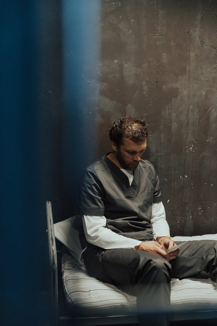 Man In Gray Robe Sitting On Matrass 