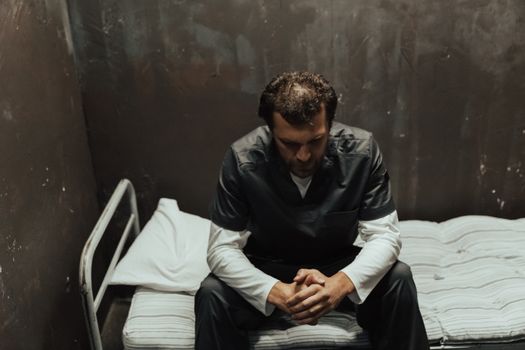 Man Sitting on the Prison Cell Bed