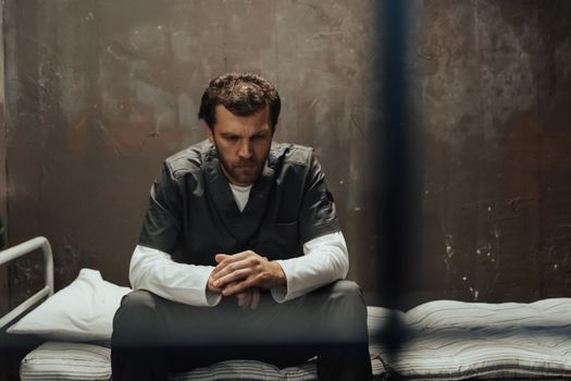 Man in Gray Dress Shirt Sitting on Bed