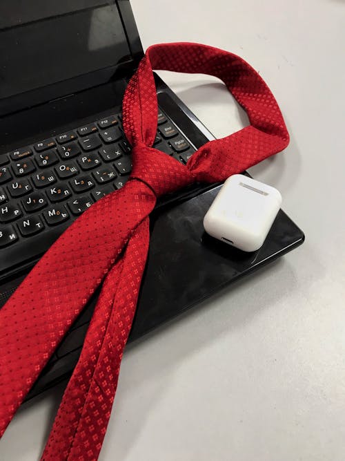 Red Necktie on Top of Black Laptop