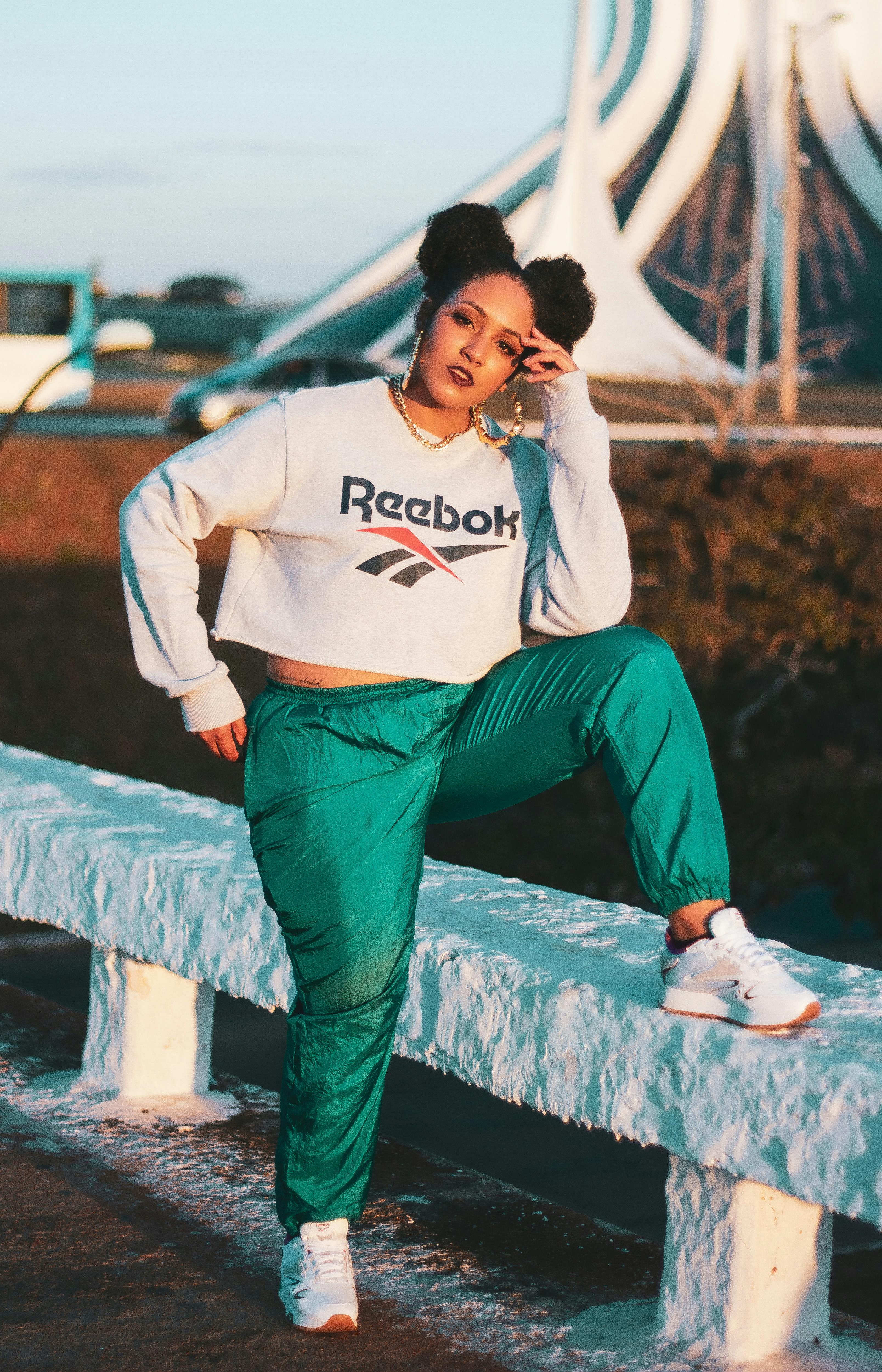 woman in white sweater and green training pants