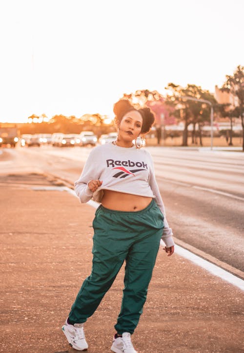 A Woman in Active Wear Walking on the Road