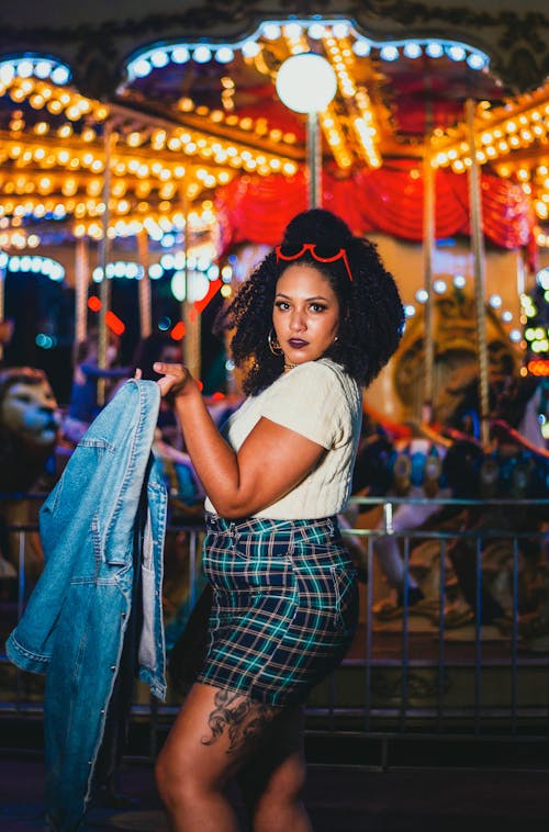 Woman in Checkered Skirt Holding a Denim Jacket