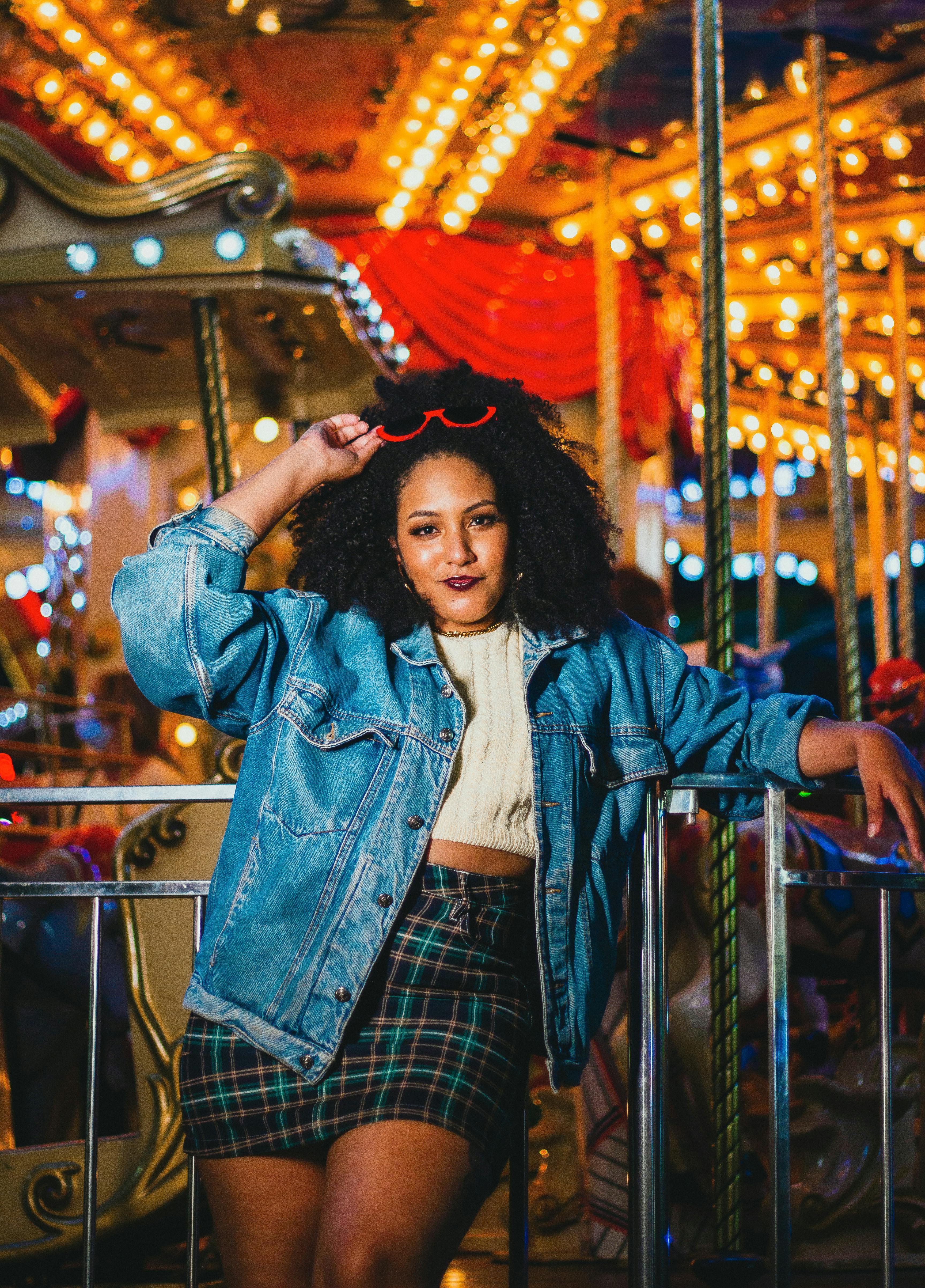 Woman in White Top and Plaid Skirt Holding Denim Jacket at Night