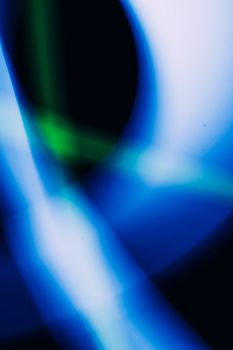 Dynamic abstract light painting with blue and green streaks creating a fluid motion effect.